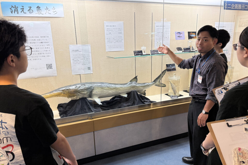 「消える魚たち」展示の前で解説する和田英敏先生